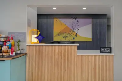 a reception desk with a tv on the wall at Spark by Hilton Carlisle South in Carlisle