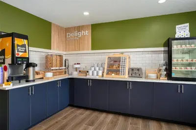 a kitchen with blue cabinets and a green wall at Spark by Hilton Carlisle South in Carlisle