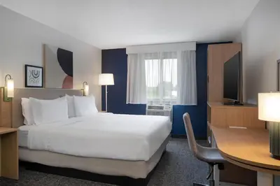a hotel room with a large bed and a desk at Spark by Hilton Carlisle South in Carlisle