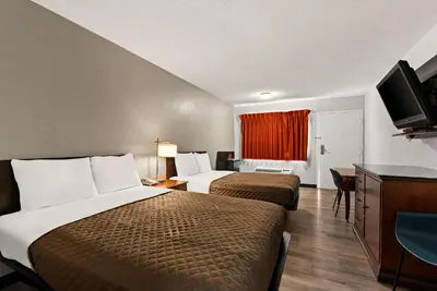 a hotel room with two beds and a flat screen tv at Rodeway Inn Brooklawn in Brooklawn