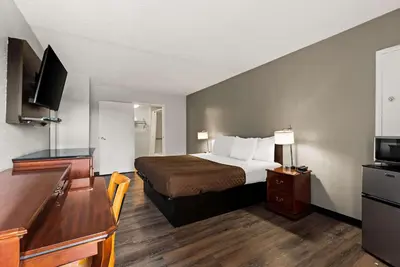 a hotel room with a bed and a flat screen tv at Rodeway Inn Brooklawn in Brooklawn