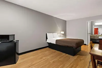 a hotel room with a bed and a television at Rodeway Inn Brooklawn in Brooklawn