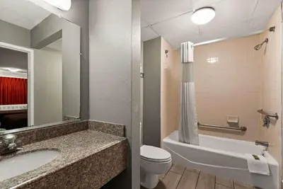 a bathroom with a sink and a toilet and a tub at Rodeway Inn Brooklawn in Brooklawn