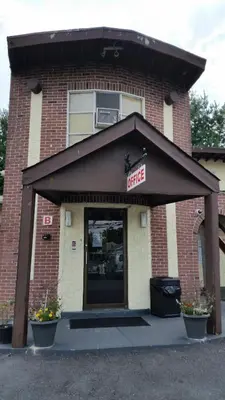 a store front of a brick building with a garage at Budget Motor Inn- Stony Point in Stony Point