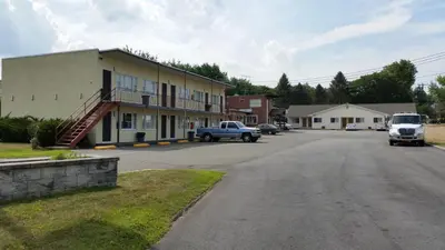 a street in a town with a building and a truck at Budget Motor Inn- Stony Point in Stony Point