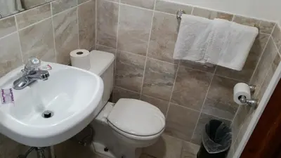 a bathroom with a white toilet and a sink at Budget Motor Inn- Stony Point in Stony Point