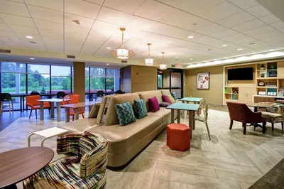 a living room with a couch and chairs and tables at Home2 Suites Mechanicsburg in Mechanicsburg