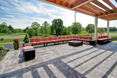 a group of red benches sitting on a patio at Home2 Suites Mechanicsburg in Mechanicsburg