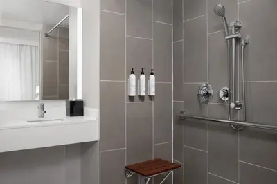 a bathroom with a shower with two bottles on the wall at TownePlace Suites by Marriott New York Manhattan/Times Square in New York