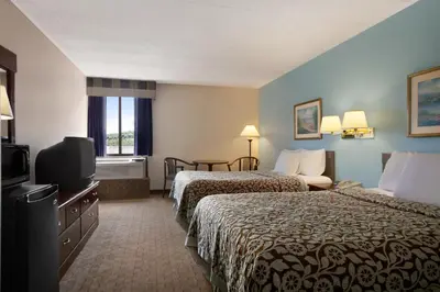 a hotel room with two beds and a flat screen tv at Days Inn by Wyndham Reading Wyomissing in Reading