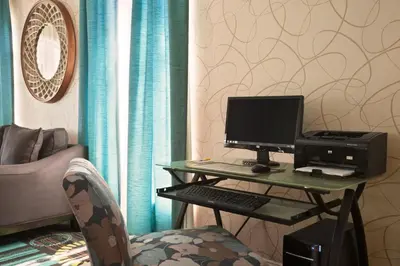 a desk with a computer and a chair in a room at Days Inn by Wyndham Reading Wyomissing in Reading