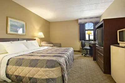 a hotel room with a bed and a television at Days Inn by Wyndham Reading Wyomissing in Reading