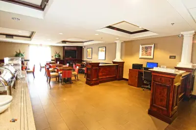 a waiting room with desks and chairs and a table at Comfort Suites Near University in North Brunswick