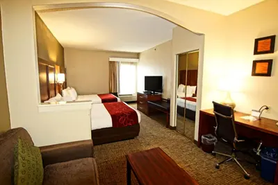 a hotel room with a bed and a desk at Comfort Suites Near University in North Brunswick