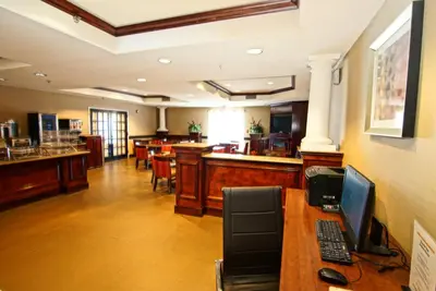 a lobby with a bar with a computer on a desk at Comfort Suites Near University in North Brunswick