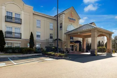 a hotel with a gazebo in a parking lot at Comfort Suites Near University in North Brunswick