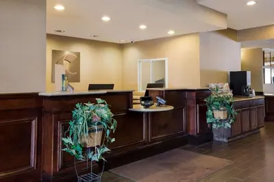 a lobby with a reception desk with plants at Comfort Suites Near University in North Brunswick