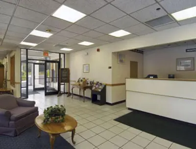 a lobby with a waiting room with a couch and a table at Knights Inn Liberty in Liberty