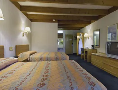 a hotel room with two beds and a flat screen tv at Knights Inn Liberty in Liberty