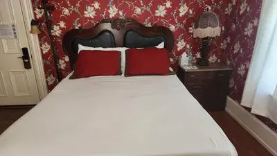 a bed with two red pillows and a red wall at Greystone Manor Bed & Breakfast in Bird in Hand