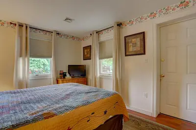 a bedroom with a bed and two windows and a television at Greystone Manor Bed & Breakfast in Bird in Hand