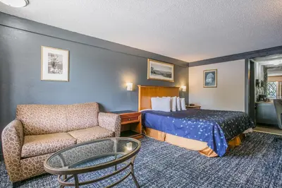 a hotel room with a bed and a chair at Scottish Inns Harrisburg-Hershey South in New Cumberland