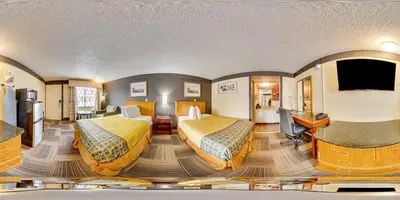 a hotel room with two beds and a flat screen tv at Scottish Inns Harrisburg-Hershey South in New Cumberland
