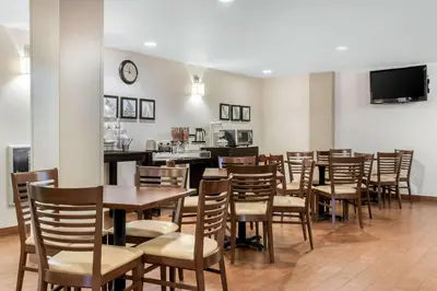 a dining room with tables and chairs and a bar at Sleep Inn Carlisle South in Carlisle