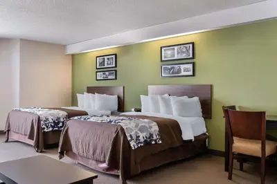 two beds in a hotel room with green walls at Sleep Inn Carlisle South in Carlisle