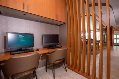 a desk with two computer monitors on top of it at Springhill Suites By Marriott Newark Downtown in Newark