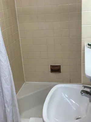 a bathroom with a white tub and a sink at White Rose Motel - Hershey in Hershey