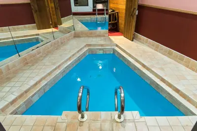 a swimming pool with a tile floor and blue water at Cove Haven Resort in Lakeville