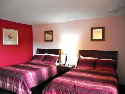 two beds in a hotel room with red walls at Motel 6 Harrisburg PA Near PA Expo Center in Harrisburg