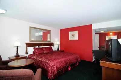 a hotel room with a bed and a red wall at Motel 6 Harrisburg PA Near PA Expo Center in Harrisburg