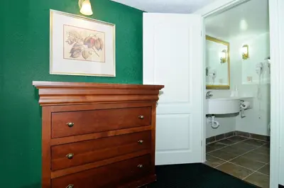 a bathroom with a wooden dresser and a sink at Motel 6 Harrisburg PA Near PA Expo Center in Harrisburg