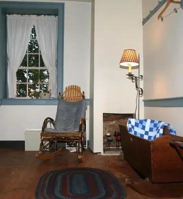 a living room with a chair and a window at Brownstone Colonial Inn in Reinholds