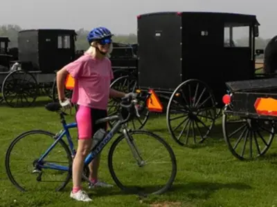 a woman standing next to a bike in the grass at Brownstone Colonial Inn in Reinholds