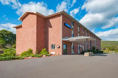 a brick building with a parking lot in front of it at Motel 6-Drums in Drums