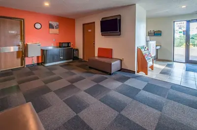 a room with orange walls and a checkerboard floor at Motel 6-Drums in Drums
