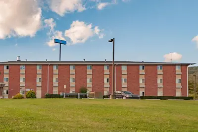 a large brick building with a parking lot in front of it at Motel 6-Drums in Drums