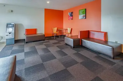 a waiting room with a cash machine and chairs at Motel 6-Drums in Drums
