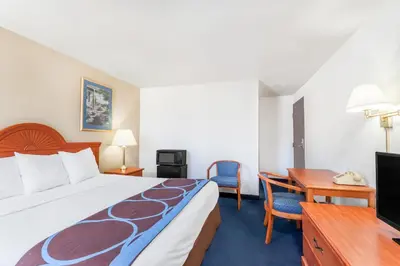 a hotel room with a large bed and a desk at Super 8 by Wyndham Montgomery Maybrook in Montgomery