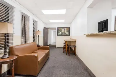 a living room with a couch and a desk at Super 8 by Wyndham Montgomery Maybrook in Montgomery