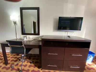 a desk with a mirror and a television in a room at Lodge Inn Wrightstown - Fort Dix in Wrightstown