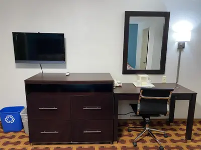 a desk with a television and a desk with a chair at Lodge Inn Wrightstown - Fort Dix in Wrightstown