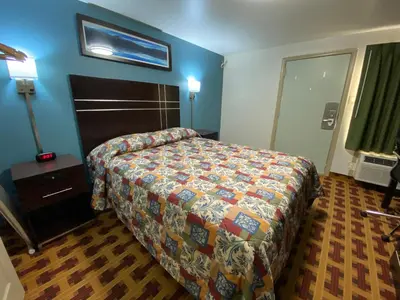 a hotel room with a bed and blue walls at Lodge Inn Wrightstown - Fort Dix in Wrightstown