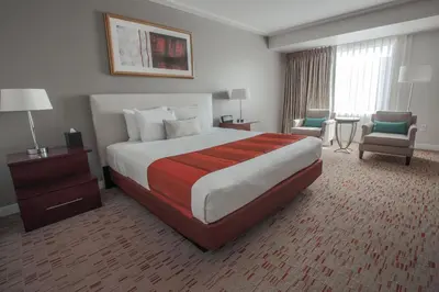 a hotel room with a large bed and a chair at Wind Creek Bethlehem Casino & Resort in Bethlehem