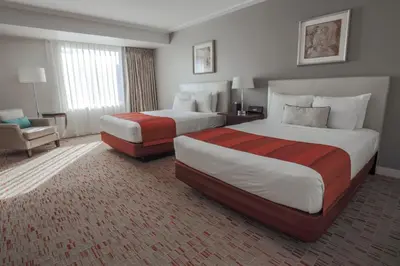 a hotel room with two beds and a chair at Wind Creek Bethlehem Casino & Resort in Bethlehem