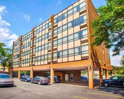 a large building with cars parked in a parking lot at Rodeway Inn Meadowlands in Secaucus