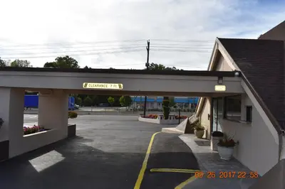 a building with a sign for a parking lot at MHO Hotel Bordentown in Bordentown